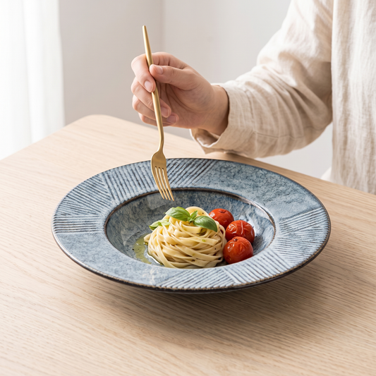 Capeline wide-brim porcelain deep plate with pasta on a pale oak table
