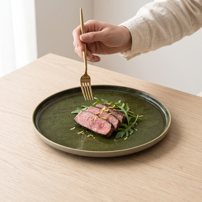 Verdigris handmade underglaze flat plate with steak on a pale oak table