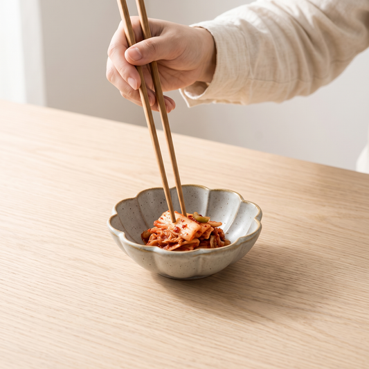 Petal glaze side dish with kimchi on a pale oak table