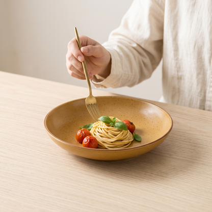 Amber retro colour-glaze deep plate with pasta on a pale oak table
