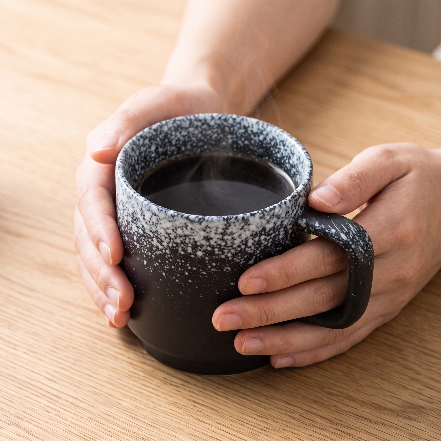 Hinode handmade ceramic mug with coffee cradled in two hands